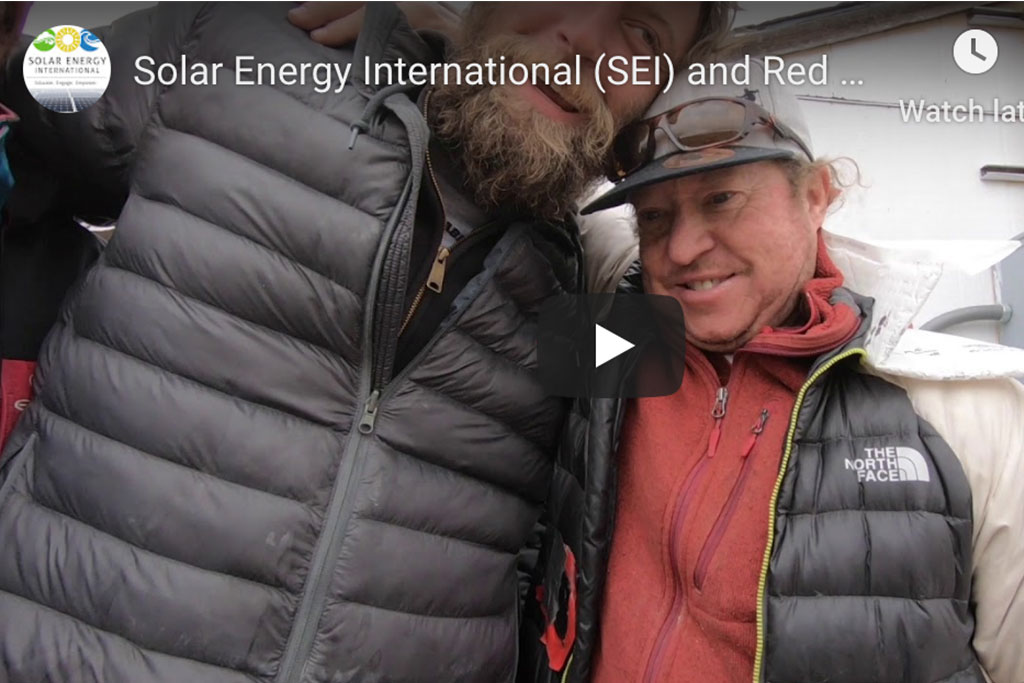 Screen shot of Solar Entergy Internaitonal video clop. Two men in the photo in winter coards. One man is very tall and has a beard.